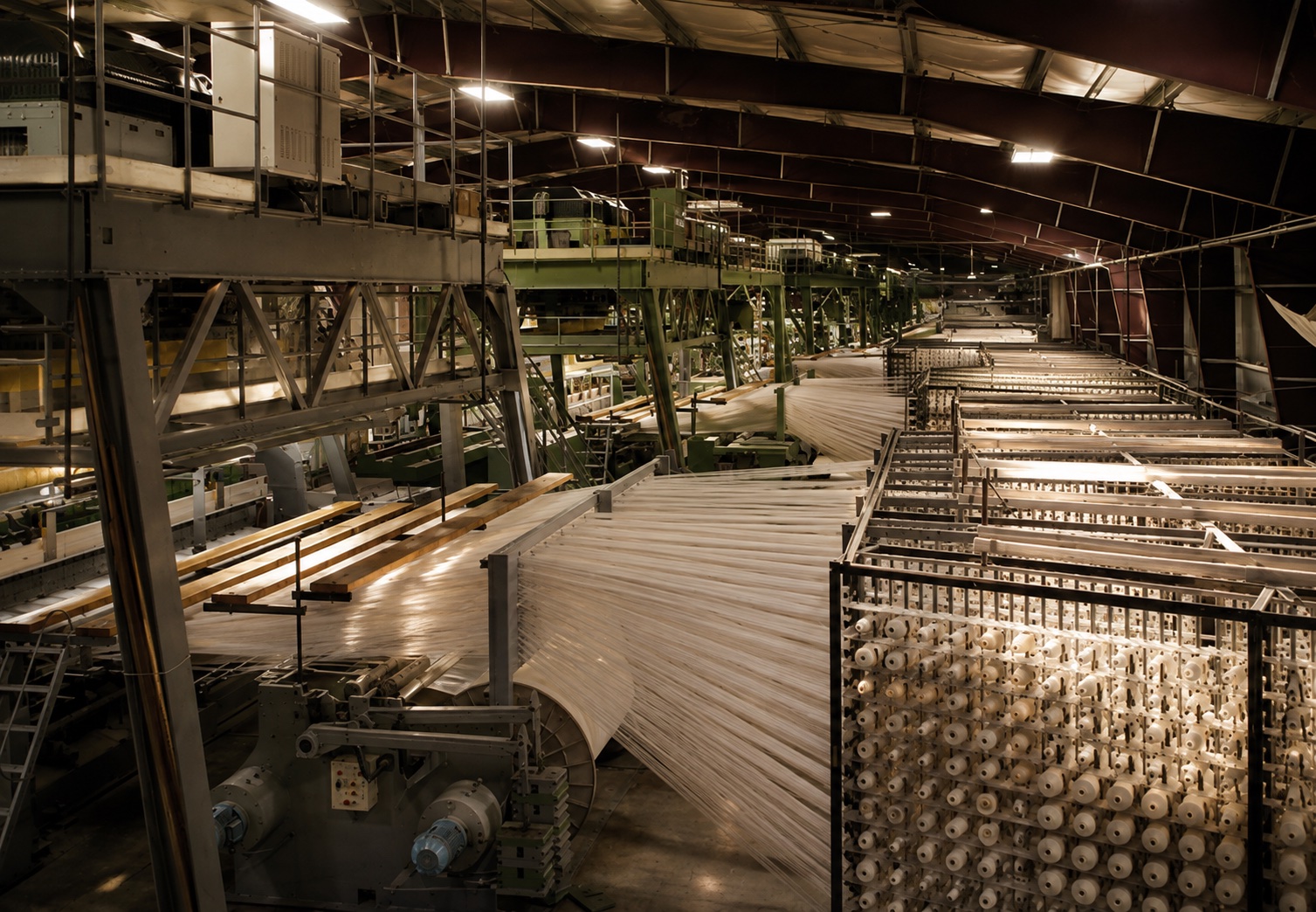Wool yarn running from a creel toward the carpet loom at Fieldmark's American partner mill